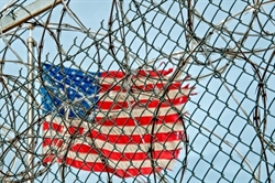 US Flag seen through a barbed wire fence